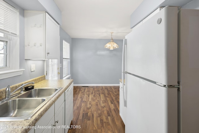 6215 Beechfield Dr, Lansing, MI 48911 - kitchen with white appliances, a sink, dark wood-style floors, white cabinetry, and decorative light fixtures