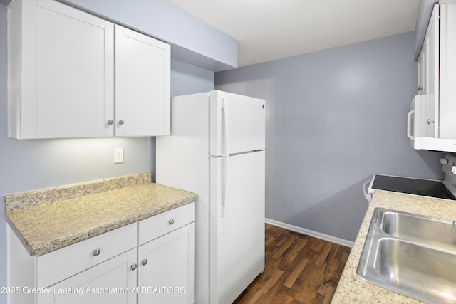 6215 Beechfield Dr, Lansing, MI 48911 - kitchen with white appliances, dark wood-type flooring, a sink, light countertops, and white cabinetry