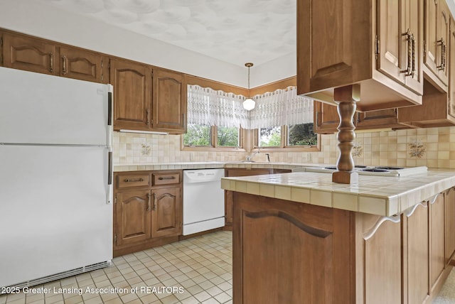 847 N Waverly Rd, Dimondale, MI 48821 - kitchen featuring white appliances, tile countertops, backsplash, and brown cabinetry