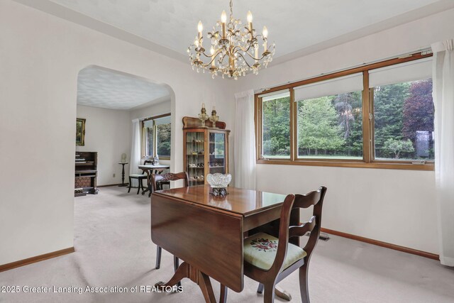 847 N Waverly Rd, Dimondale, MI 48821 - dining area featuring arched walkways, light colored carpet, baseboards, and a chandelier