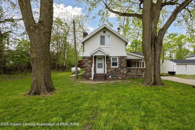 1900 Kaplan St, Lansing, MI 48917 - view of front of house with stone siding, a chimney, and a front lawn