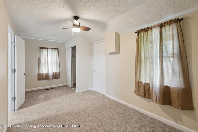 1900 Kaplan St, Lansing, MI 48917 - unfurnished bedroom with a textured ceiling, carpet flooring, a closet, baseboards, and a ceiling fan