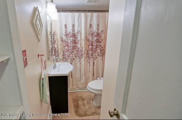 711 W Henry St, Charlotte, MI 48813 - full bath with toilet, vanity, a shower with curtain, and tile patterned flooring