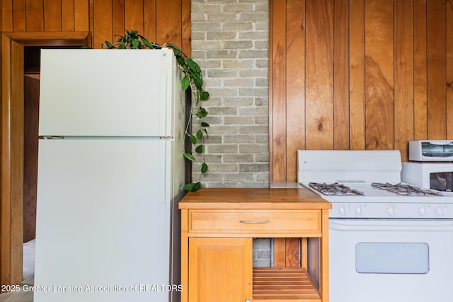3129 Birch Row Dr, East Lansing, MI 48823 - kitchen featuring white appliances, wooden walls, and light countertops