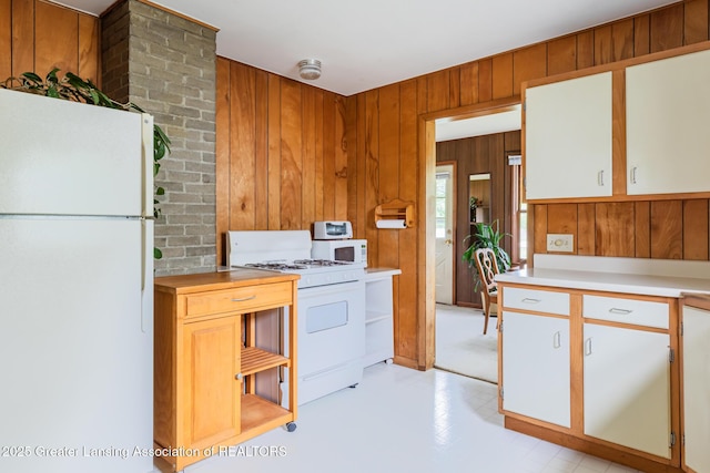 3129 Birch Row Dr, East Lansing, MI 48823 - kitchen with white appliances, light countertops, and wooden walls