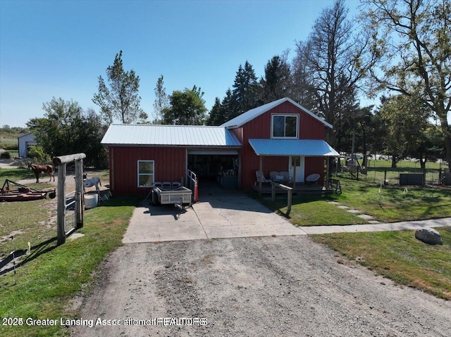 13862 Hartel Rd, Grand Ledge, MI 48837 - view of front facade featuring driveway, metal roof, and a front yard