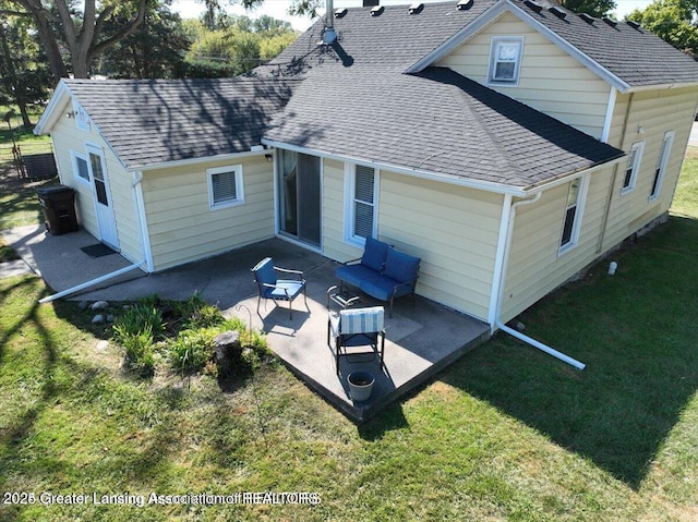 13862 Hartel Rd, Grand Ledge, MI 48837 - rear view of property featuring a shingled roof, a patio, and a lawn