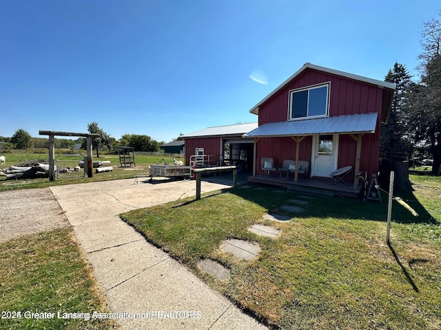 13862 Hartel Rd, Grand Ledge, MI 48837 - back of house featuring a yard, board and batten siding, and metal roof