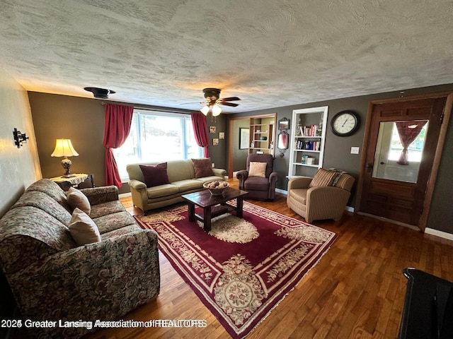 13862 Hartel Rd, Grand Ledge, MI 48837 - living area with a textured ceiling, wood finished floors, a ceiling fan, built in shelves, and baseboards