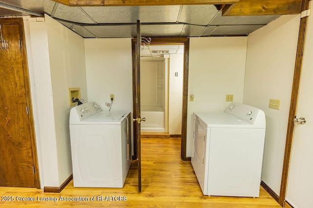 2278 Narrow Lake Rd, Charlotte, MI 48813 - laundry area featuring washing machine and dryer, light wood-style flooring, and baseboards