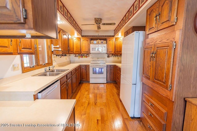 2278 Narrow Lake Rd, Charlotte, MI 48813 - kitchen with white appliances, brown cabinets, a sink, light wood finished floors, and light countertops