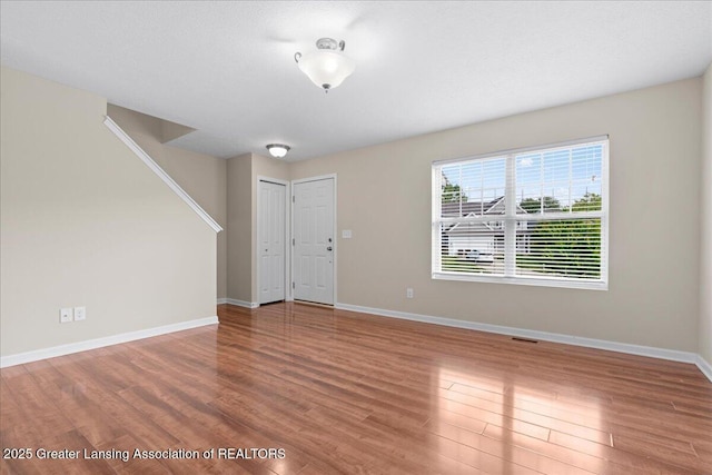 4026 Watts Ln, Lansing, MI 48911 - entrance foyer featuring wood finished floors, baseboards, and stairway