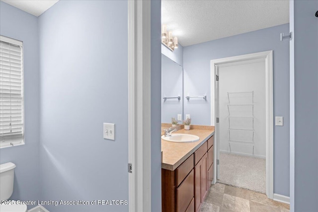 4026 Watts Ln, Lansing, MI 48911 - bathroom featuring vanity, toilet, and a textured ceiling