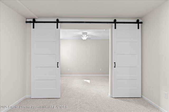 4026 Watts Ln, Lansing, MI 48911 - unfurnished room with a barn door, carpet floors, baseboards, and ceiling fan