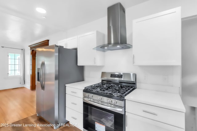 414 W St, Lansing, MI 48915 - kitchen with appliances with stainless steel finishes, ventilation hood, light countertops, white cabinets, and recessed lighting