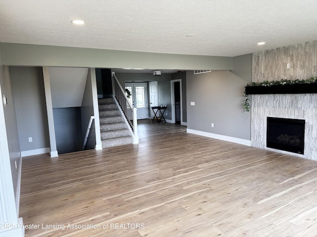 9135 Klein Farm, Grand Ledge, MI 48837 - unfurnished living room featuring stairway, wood finished floors, baseboards, recessed lighting, and a textured ceiling