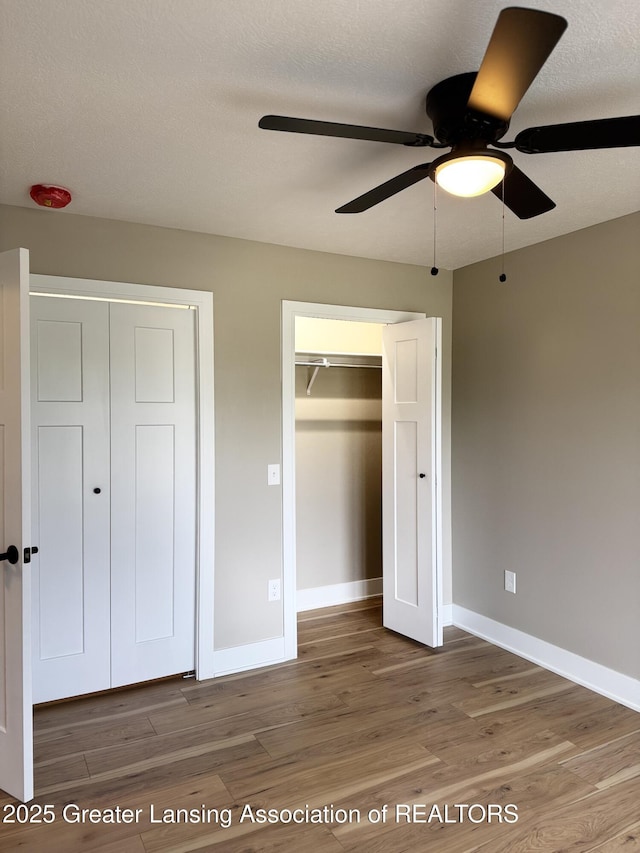 9135 Klein Farm, Grand Ledge, MI 48837 - unfurnished bedroom with wood finished floors, baseboards, and a ceiling fan