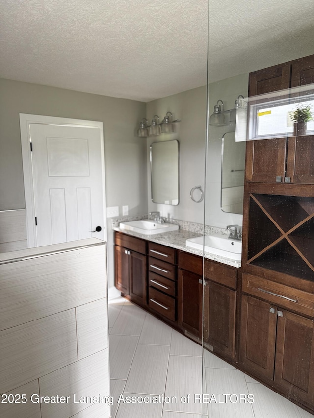 9135 Klein Farm, Grand Ledge, MI 48837 - bathroom featuring double vanity, a textured ceiling, and tile patterned floors