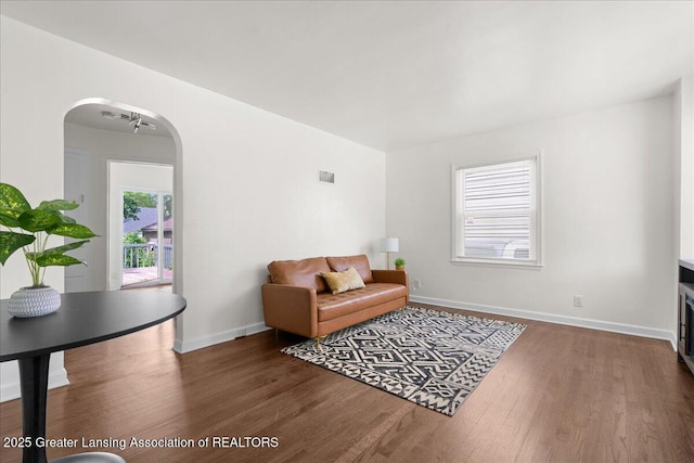 1200 W Rundle Ave, Lansing, MI 48910 - living area featuring wood finished floors, arched walkways, and baseboards