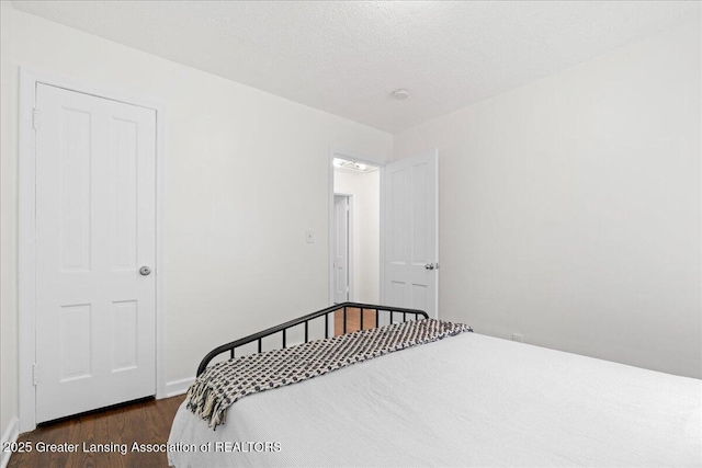 1200 W Rundle Ave, Lansing, MI 48910 - bedroom featuring dark wood-style flooring, baseboards, and a textured ceiling