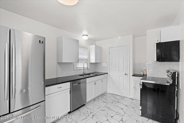 1200 W Rundle Ave, Lansing, MI 48910 - kitchen featuring appliances with stainless steel finishes, a sink, light marble finish flooring, and dark countertops