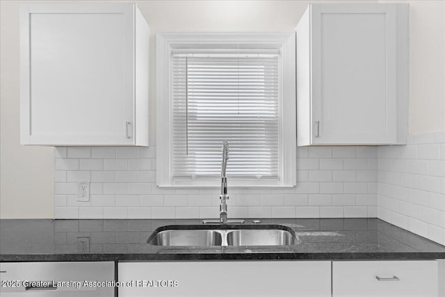 1200 W Rundle Ave, Lansing, MI 48910 - kitchen with a sink, white cabinets, dark stone countertops, and backsplash