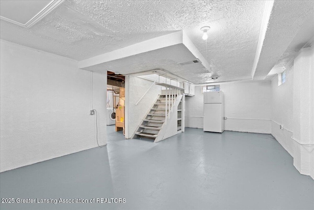 1200 W Rundle Ave, Lansing, MI 48910 - below grade area featuring freestanding refrigerator, stairway, a textured ceiling, and washer / dryer