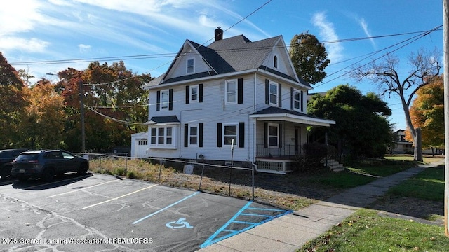 411 W Ionia St, Lansing, MI 48933 - view of front of home with covered porch, uncovered parking, and a chimney