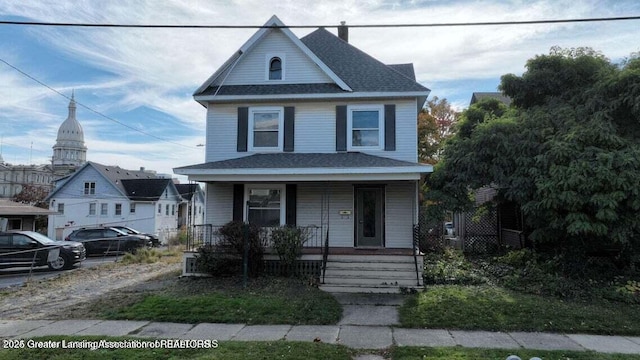 411 W Ionia St, Lansing, MI 48933 - view of front of home with covered porch, a chimney, and roof with shingles