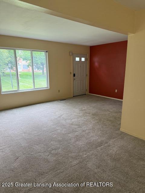 956 Trafalger Ln, East Lansing, MI 48823 - unfurnished living room featuring carpet flooring and baseboards