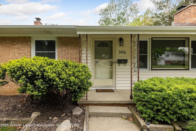 1416 Briarwood Dr, Lansing, MI 48917 - property entrance featuring a chimney and brick siding