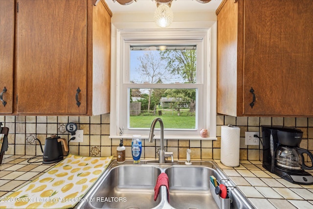 1416 Briarwood Dr, Lansing, MI 48917 - kitchen with a sink, tile counters, plenty of natural light, and decorative backsplash