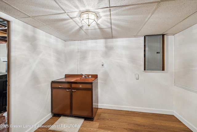 1416 Briarwood Dr, Lansing, MI 48917 - bathroom with a drop ceiling, electric panel, baseboards, wood finished floors, and a sink