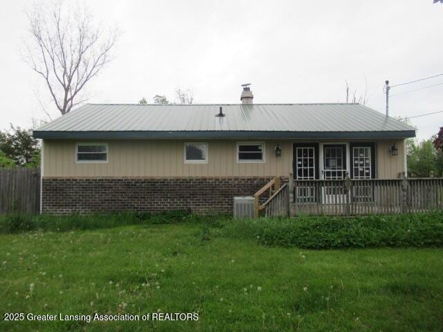 2071 Vandekarr Rd, Owosso, MI 48867 - back of property featuring brick siding, a yard, a chimney, and a deck