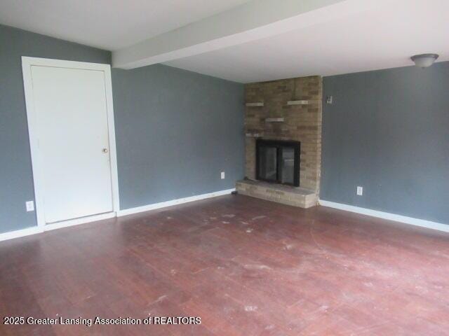 2071 Vandekarr Rd, Owosso, MI 48867 - unfurnished living room with a fireplace, baseboards, wood finished floors, and beam ceiling