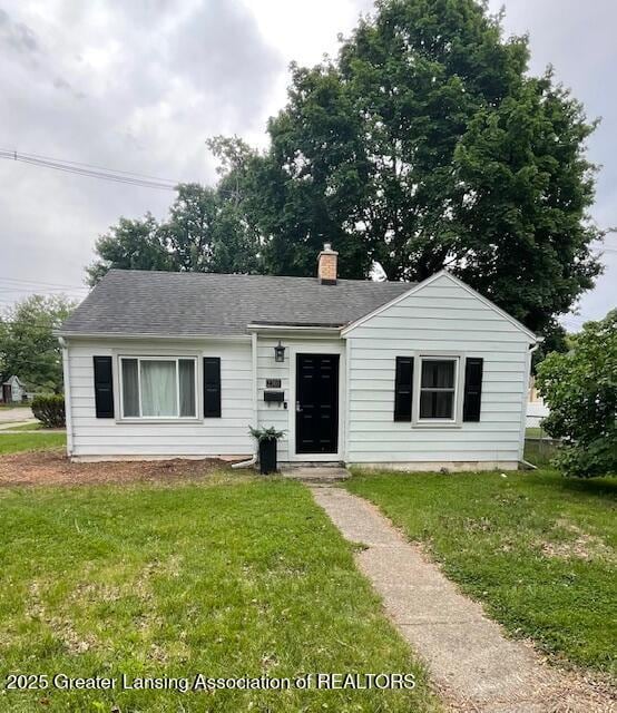 2303 Devonshire Ave, Lansing, MI 48910 - bungalow-style house featuring a front lawn, a chimney, and roof with shingles
