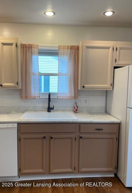 2303 Devonshire Ave, Lansing, MI 48910 - kitchen featuring white appliances, a sink, tasteful backsplash, and recessed lighting
