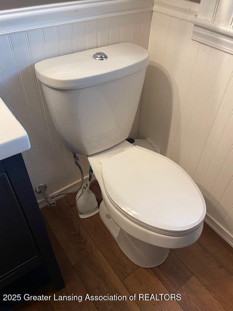 2303 Devonshire Ave, Lansing, MI 48910 - bathroom with wood finished floors, toilet, and a decorative wall