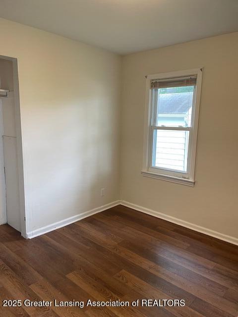 2303 Devonshire Ave, Lansing, MI 48910 - empty room with dark wood finished floors and baseboards