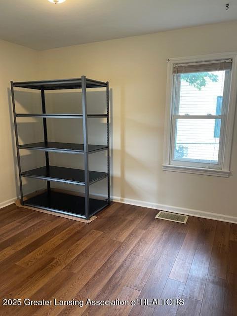 2303 Devonshire Ave, Lansing, MI 48910 - unfurnished room featuring dark wood-style flooring and baseboards