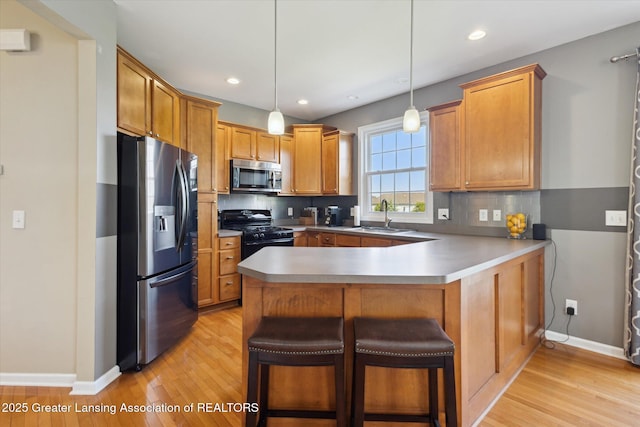 3893 E Plover Pl, East Lansing, MI 48823 - kitchen featuring stainless steel appliances, a sink, light wood-style floors, baseboards, and recessed lighting