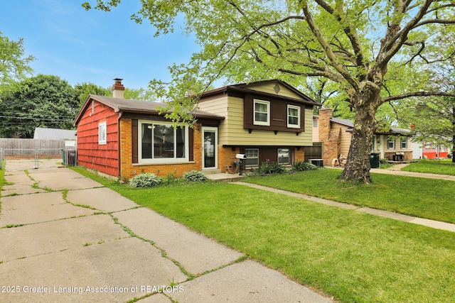 4716 Wainwright Ave, Lansing, MI 48911 - split level home featuring a chimney and brick siding