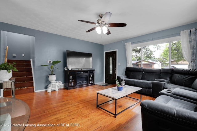 4716 Wainwright Ave, Lansing, MI 48911 - living area with a ceiling fan, light wood finished floors, baseboards, and stairs