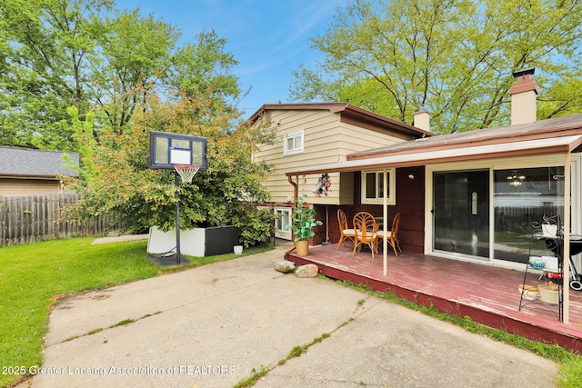 4716 Wainwright Ave, Lansing, MI 48911 - rear view of property featuring a wooden deck, a chimney, and a patio area