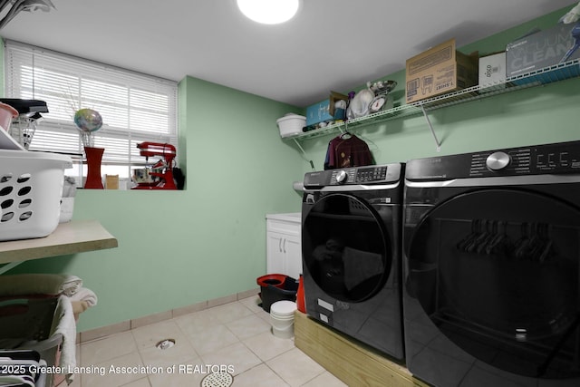 4716 Wainwright Ave, Lansing, MI 48911 - laundry room featuring separate washer and dryer, cabinet space, and light tile patterned floors