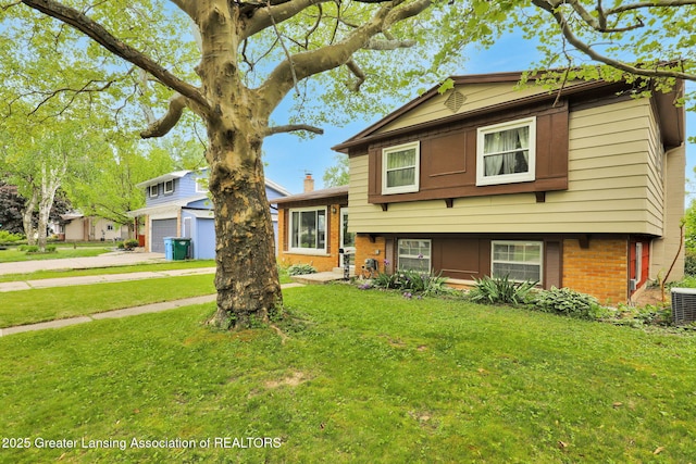 4716 Wainwright Ave, Lansing, MI 48911 - view of front of property with brick siding, a front lawn, a garage, and cooling unit