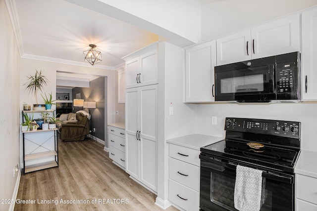 2022 Greenwich Ct, Lansing, MI 48910 - kitchen with black appliances, light countertops, white cabinetry, light wood-style flooring, and ornamental molding