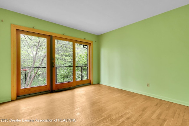 1450 N Hagadorn Rd, East Lansing, MI 48823 - unfurnished room featuring plenty of natural light, wood finished floors, and baseboards