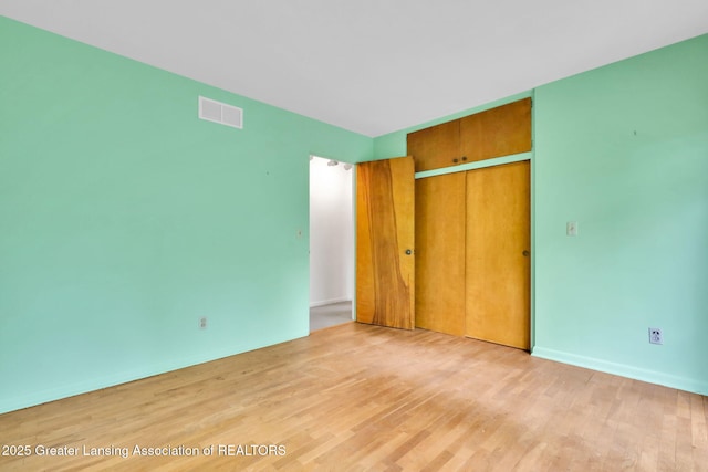 1450 N Hagadorn Rd, East Lansing, MI 48823 - unfurnished bedroom with light wood-style floors, a closet, and baseboards