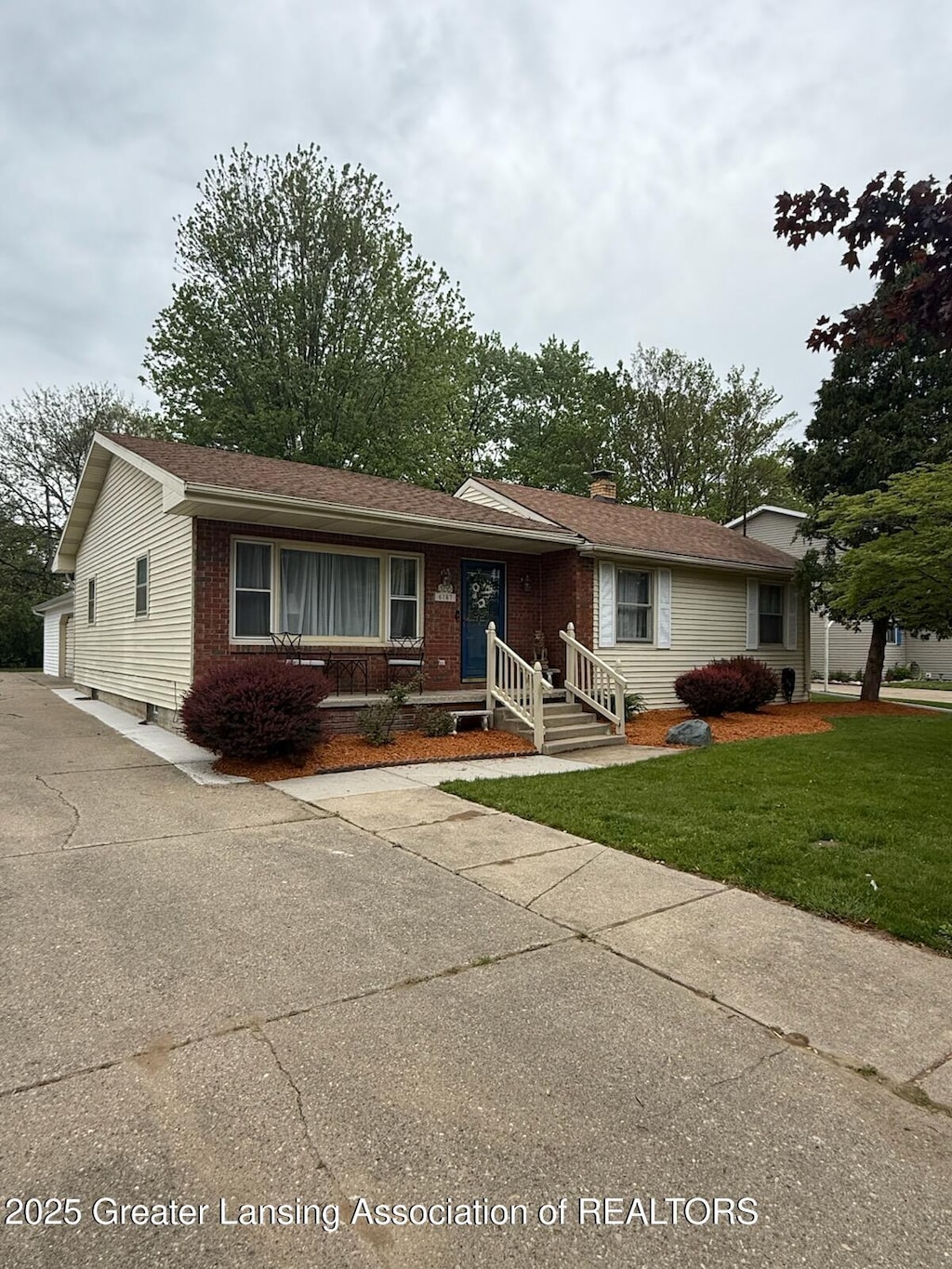 6187 Towar Ave, East Lansing, MI 48823 - ranch-style house featuring brick siding, a front yard, and a chimney